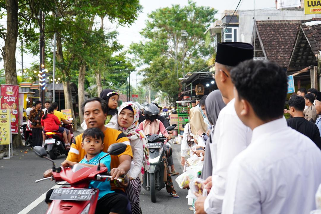 Anggota KOMITS membagikan takjil kepada pengendara di jalan sekitar sekolah